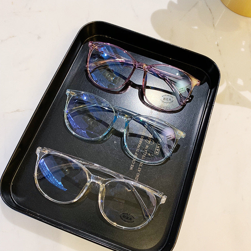 Three pairs of eyeglasses on a black tray