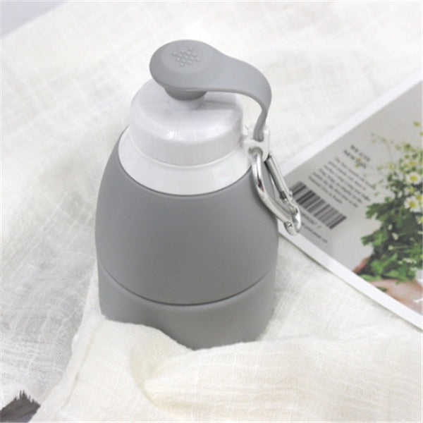 Gray insulated bottle with a keychain on a white surface