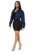 Woman wearing a black dress with a blue denim jacket on a white background