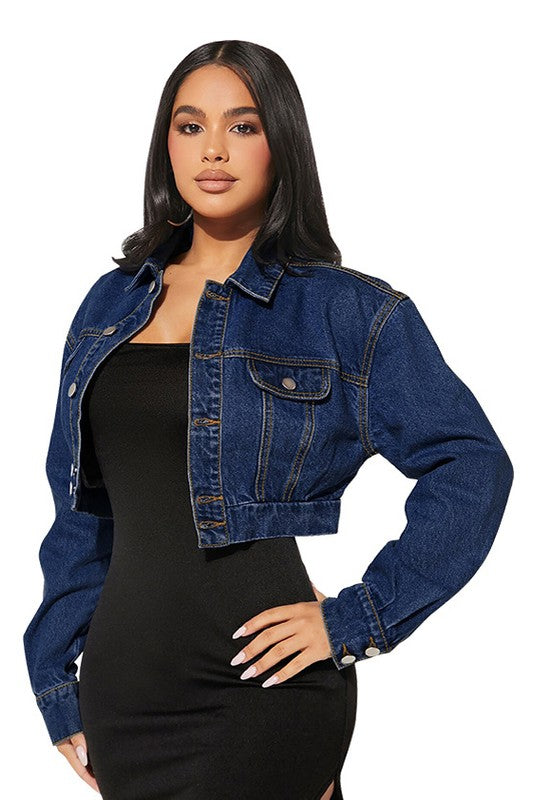 Woman wearing a blue denim jacket over a black dress on a white background