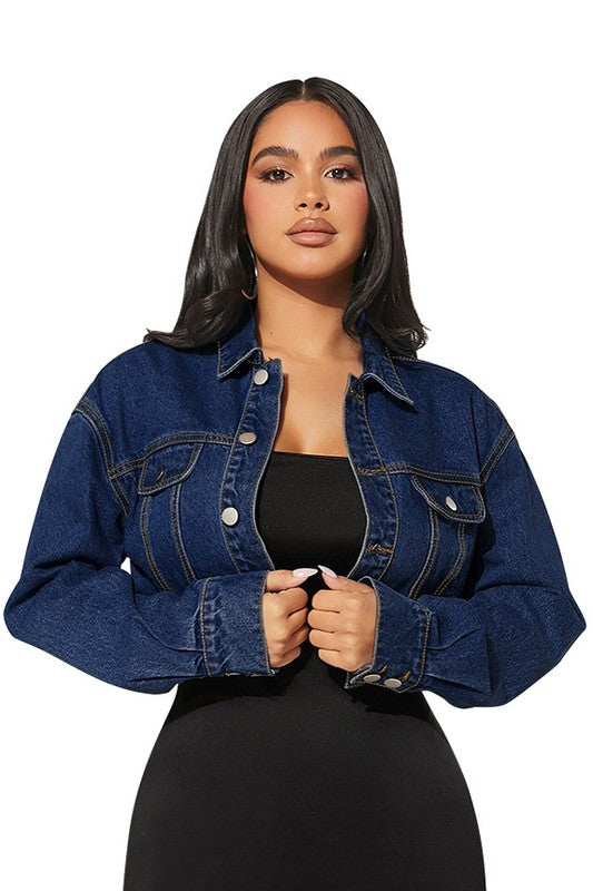 Woman wearing a black dress with a blue denim jacket on a white background