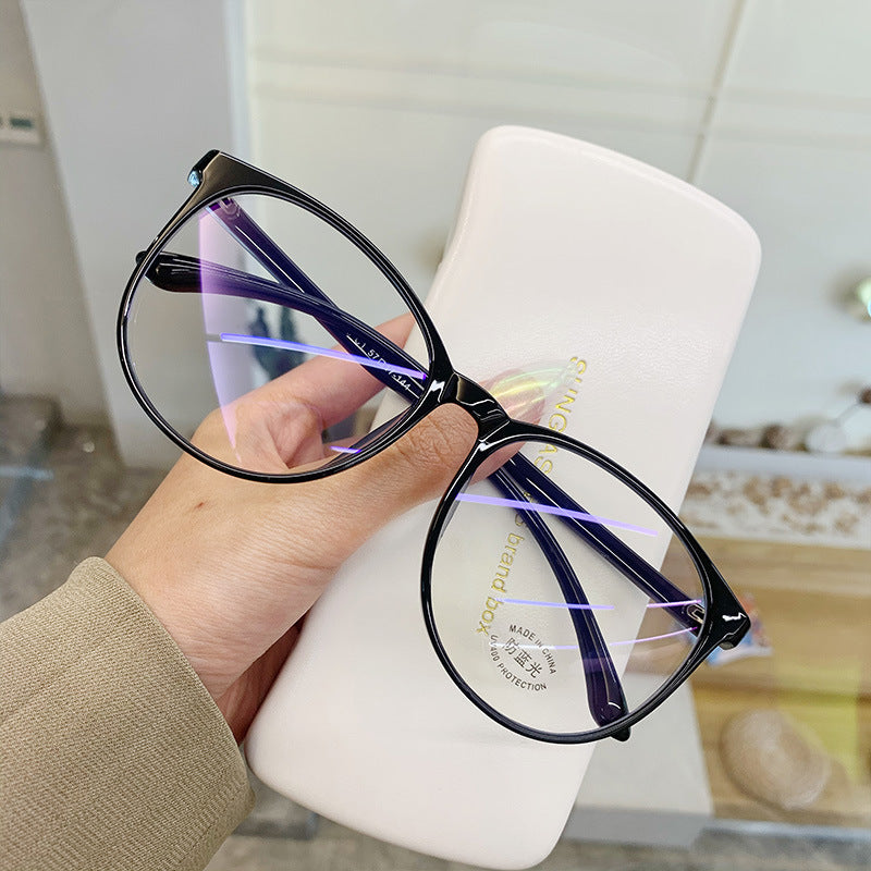 Black eyeglasses held by a hand with a white case