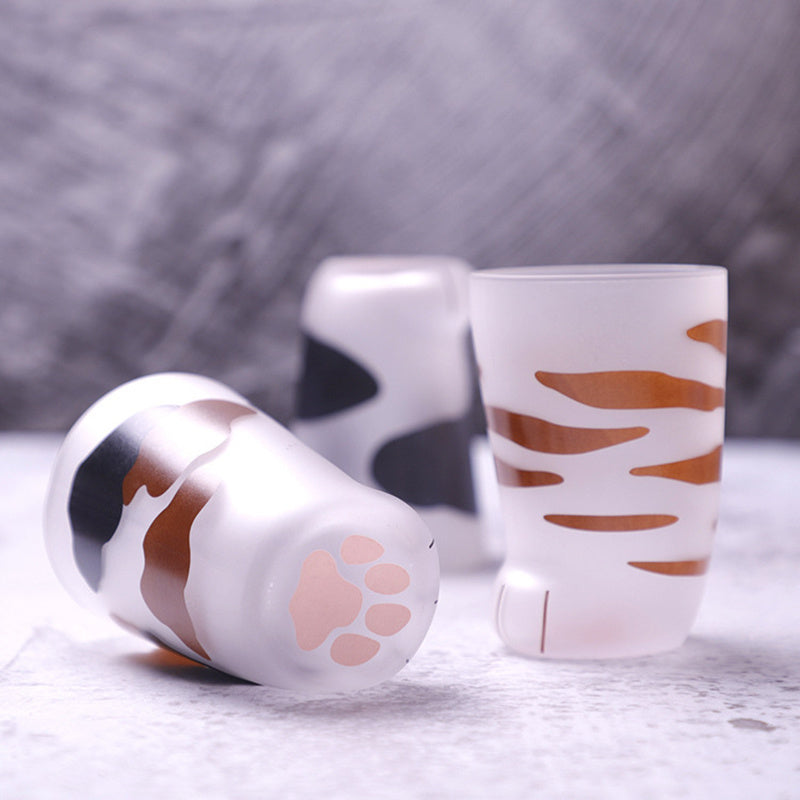 Two cylindrical containers with animal print designs on a gray surface.