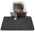Cat standing on a black perforated mat with a litter box