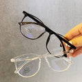 Black and clear eyeglasses held