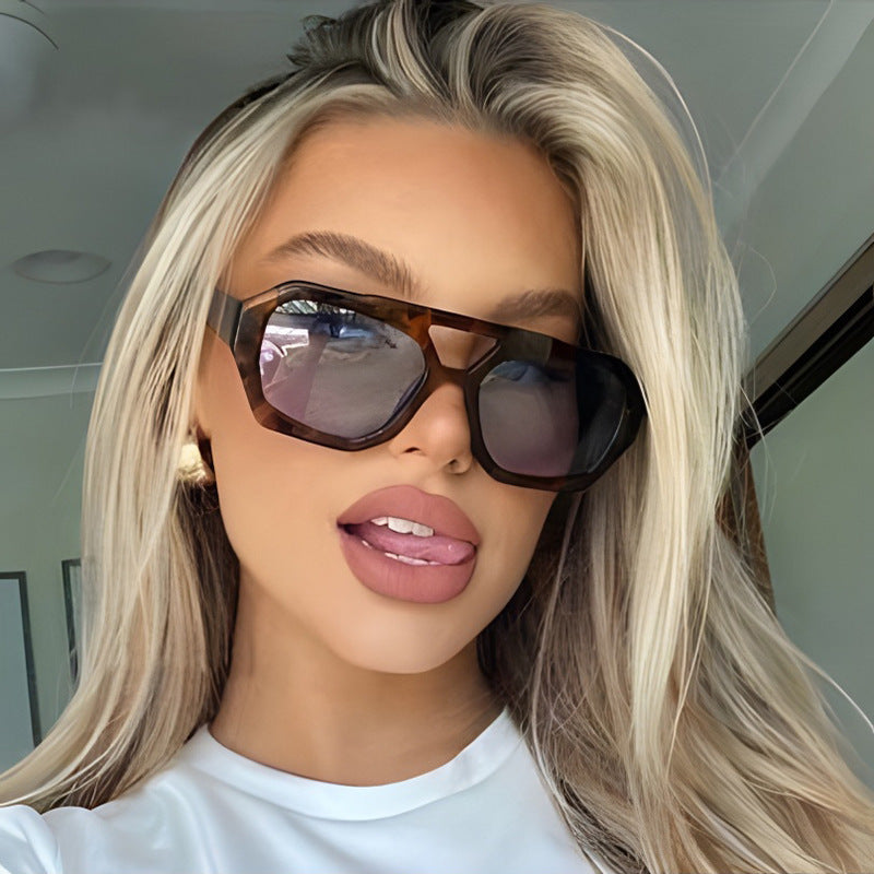 Person wearing sunglasses and a white shirt indoors