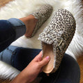Leopard print loafers with embellishments on a fluffy white surface