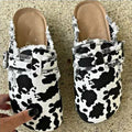 Cow print sandals on a textured surface
