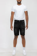 Person wearing a white t-shirt and black distressed shorts on a white background