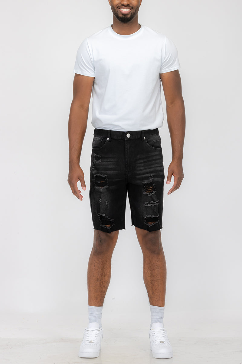 Person wearing a white t-shirt and black distressed shorts on a white background